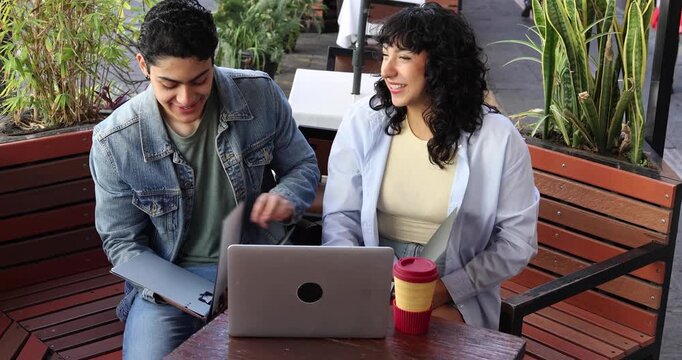 group of latinos young friends using laptop and having fun outdoors in terrace in Mexico Latin America 