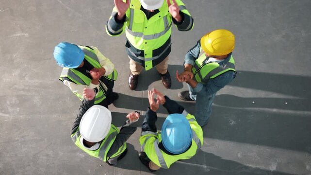 Team, huddle or architect with hands together for construction success, cohesion or inclusion. Top view, people or group of contractors piling with applause for winning, celebration or unity in depot
