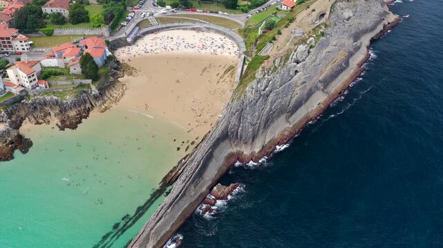 Aerial View of the Golden Sand Beach, Turquoise Ocean Water, and Sea Cliffs at Playa del Sabl&oacute;n Below Paseo de San Pedro in Llanes, Asturias, Northern Spain