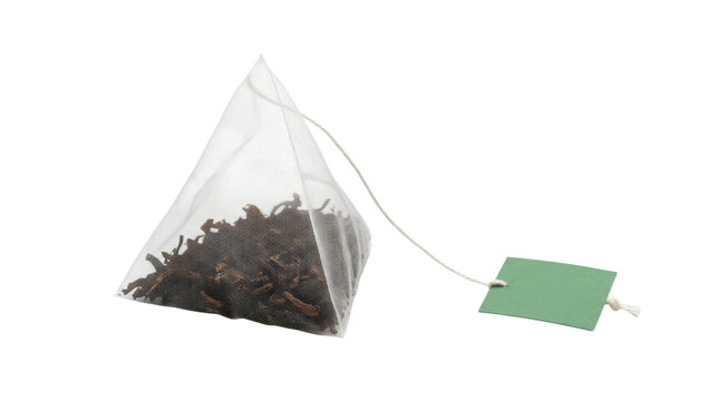 Pyramid tea bag with dry leaves and green label on a transparent background PNG file