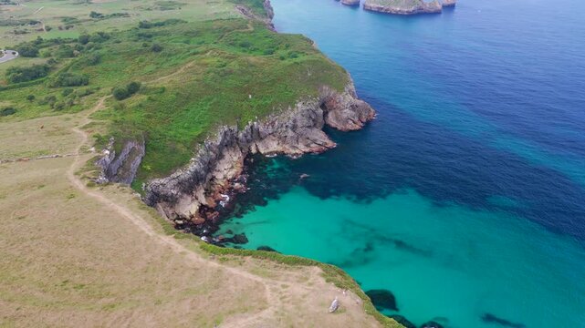 Aerial View of the Sea Cliffs and Green Grass Footpath Along Paseo de San Pedro Hiking Trail in Llanes, Asturias, Northern Spain