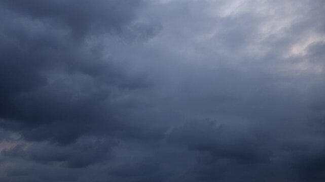 A dramatic 4K time-lapse of dark storm clouds rolling across the sky, showcasing the powerful movement and changing patterns of an approaching storm.