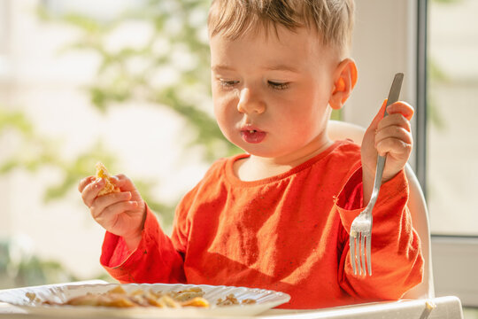 Preschool child learning independent eating with homemade cottage cheese blintzes.
