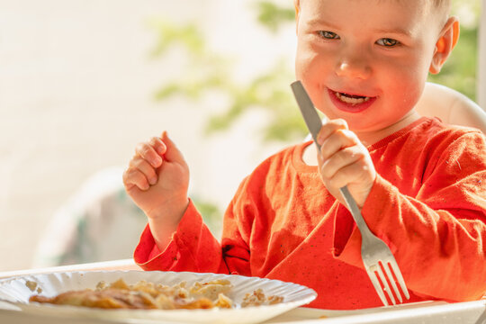 Happy preschooler eating homemade blintzes filled with creamy cottage cheese.