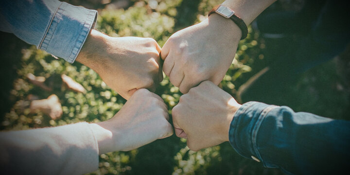 Teamwork and being united like many hands coming together in a fist bump