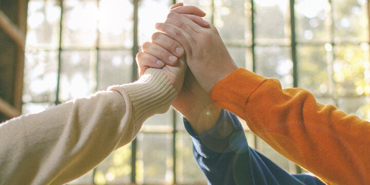 Collaboration and trust in working together with an image of many hands coming together in a teamwork gesture