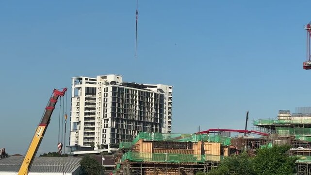 Close up of a massive industrial crawler crane operating at a bridge construction project.