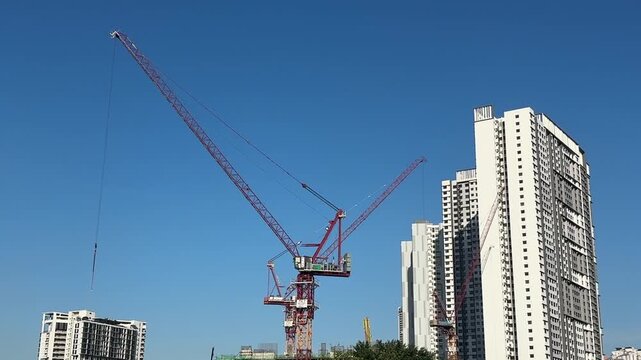 Close up of a massive industrial crawler crane operating at a bridge construction project.