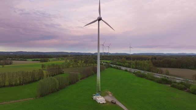 Windrad wird langsam mit Drohne umflogen.  Wolkig und das Windrad dreht sich schnell. Erneuerbare Energien. Blick auf die Autobahn A2 von oben. D-Log-Originale vorhanden. 