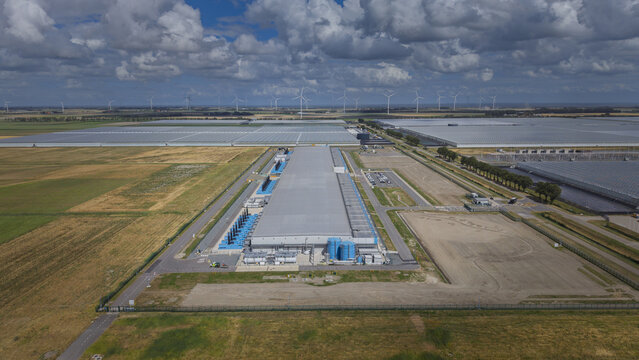 Aerial view of the Google data center at Agriport A7 surrounded by vast greenhouses, agricultural fields, and wind turbines in Middenmeer, North Holland, Netherlands.