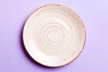 Fototapeta premium Top view of isolated of colored background empty round beige plate for food. Empty dish with space for your design