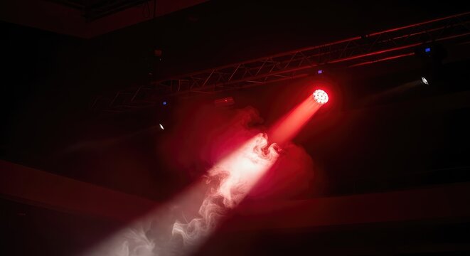 Intense red light beams pierce through thick artificial fog from a professional ceiling rig in a dark, empty concert hall or theater space, optics, energy, rig