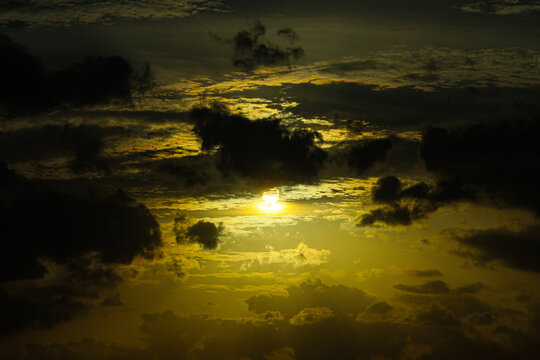 Sunbeam pierces through a heavy cloud layer to highlight the texture of the sky at twilight time.