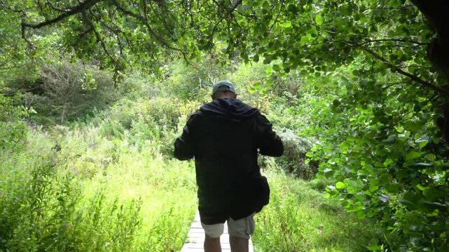 Hirtshals, Sweden A man walks on a wooden boardwalk on a hiking trail through the dunes. 