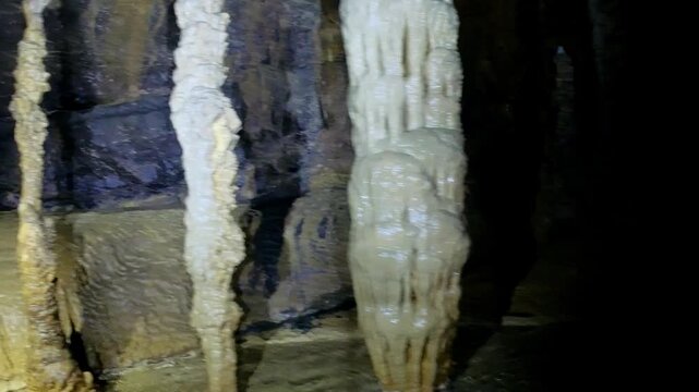 Underground cave passage with mineral formations and stalactites