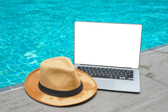 hat and laptop on pool. Laptop nearby swimming pool. Vacation working on laptop in holiday online meeting working digital Freelance work concept, Traveler working online using computer while traveling