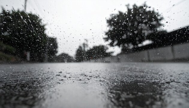 濡れたアスファルトの表面に激しい雨が降り注ぐ