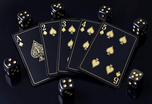 Black and gold playing cards with ace two three four and five spades next to dice arrangement