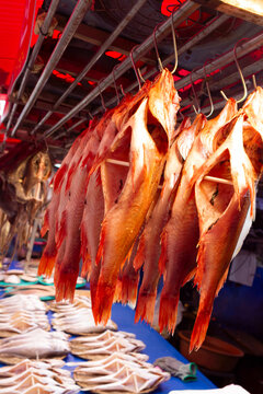 Dried fish hang on hooks in a Korean market in Busan, South Korea
