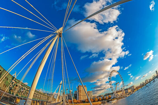 LONDON, ENGLAND - NOVEMBER 29, 2017: View with famous London Eye from Golden Jubilee and Hungerford Bridges cross the River Thames. Sunset time.