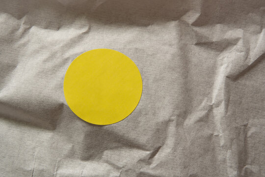 Yellow Circular Sticker Mockup on Crumpled Wrapping Paper Texture