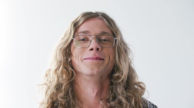 Confident Caucasian man wearing eyeglasses and closing one eye with playful expression. Portrait male showing personality and relaxed mood against clean background. Modern lifestyle concept.