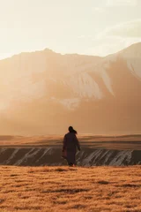 Asian Woman Standing in Golden Steppe Landscape with Snowy Mountain Range at Sary Jaz Valley © Mumemories