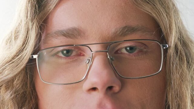 Close up Caucasian man wearing eyeglasses and closing eyes with calm expression. Male relaxing during work break and practicing mindfulness. Peaceful moment indoors. Wellness concept.