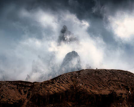 Dramatic Alpine Dolomites Peak Rising Through Storm Clouds Foggy at Italy
