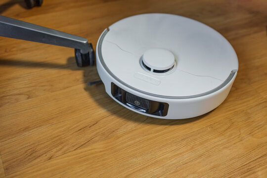Robot Vacuum Cleaner on Hardwood Floor Smart Home Cleaning Device