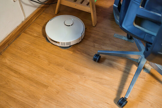 Robot Vacuum Cleaner on Hardwood Floor Smart Home Cleaning Device