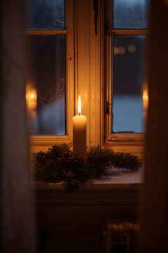 Candle and pine sprig on windowsill glowing softly evoking intimate festive mood with film look generative AI