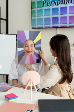 Stylist consulting client with color palettes in creative studio