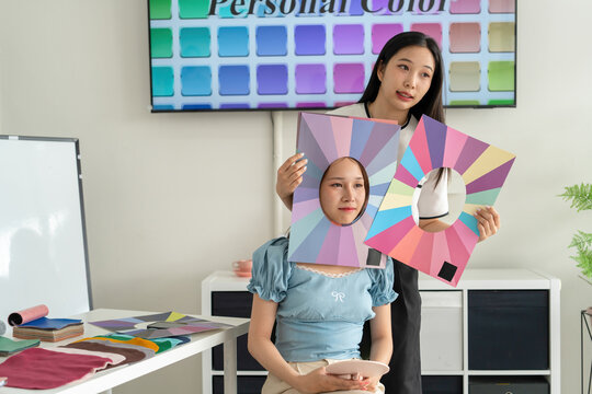 Stylist consulting client with color palettes in creative studio