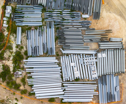 Aerial view of organized steel construction beams and girders stored at a construction site in Serravalle Scrivia, Piedmont, Italy.