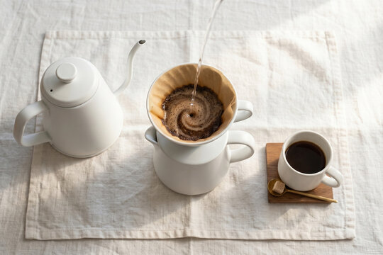 Pour-Over Coffee Ritual: A meticulous pour-over coffee preparation, with hot water gently cascading into the filter, creating a mesmerizing swirl as rich coffee brews into a waiting mug.