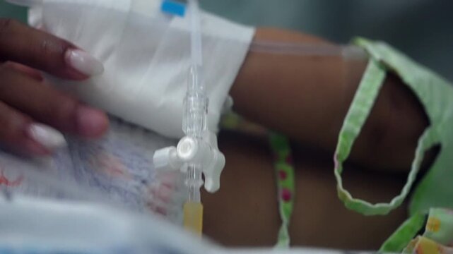 Close-up of a hospitalized infant receiving intravenous therapy through a secured IV line, highlighting pediatric healthcare, medical intervention, illness and recovery care.
