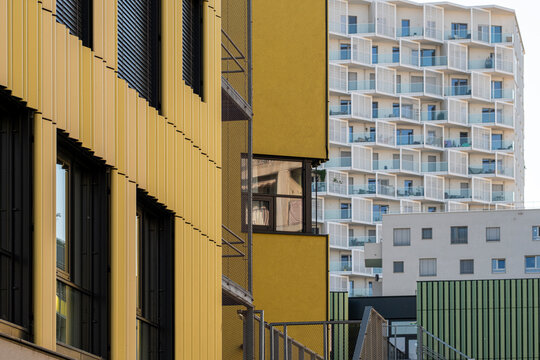 Perspective opens through layers of yellow facades, leading the eye toward white balconies and apartments at varying depths in Nordbahnviertel, Vienna, Austria.