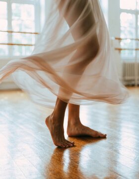 Elegant dance motion showcasing the dancer's bare feet in a flowing dress during a spin reflecting creativity and lifestyle in a tranquil studio environment