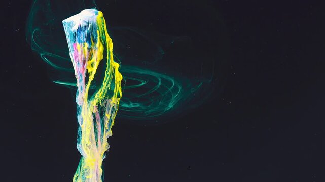 Colorful paint plume rising with teal smoke trails against black background in cinematic wide crop