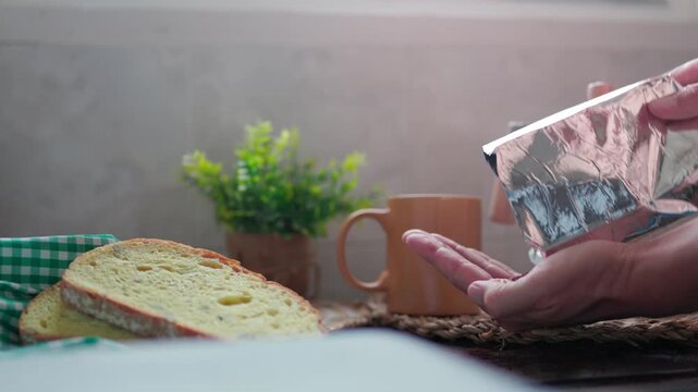 Morning routine with hands pouring ground coffee from a bag into a palm to check its quality 