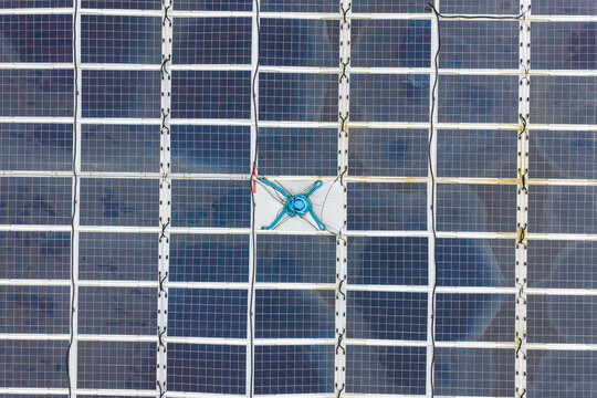 Aerial view of a solar panel array featuring a central cleaning device attached to the panels in Liabygda, More og Romsdal, Norway.
