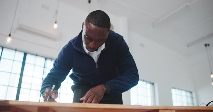 Architecture, office and black man at desk for writing, drawing and blueprint for building design. Creative, low angle and person with layout, ideas and planning for renovation, remodeling and sketch