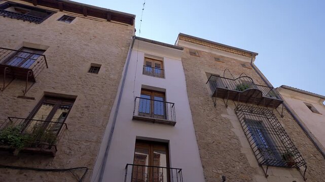 Low angle view of historic stone facades and balconies on Calle San Pedro in Cuenca Spain