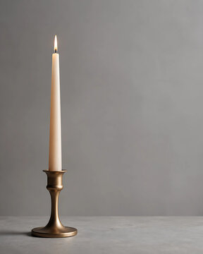 Lit Taper Candle in Brass Candlestick on Marble Surface