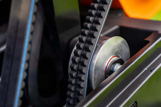 Industrial mechanical power transmission drive mechanism featuring double cogged belts and metal sheave pulley representing heavy equipment leasing