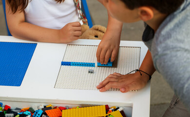 Robotics instructor demonstrates building techniques to a young student during a beginner STEM workshop, encouraging practical learning, creativity and problem-solving. © Samir