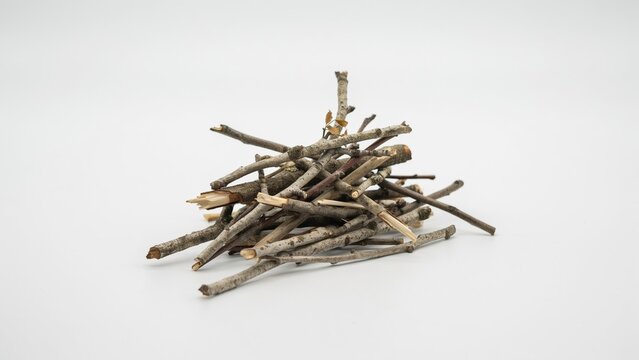 A pile of small dry wooden twigs and branches isolated on white background