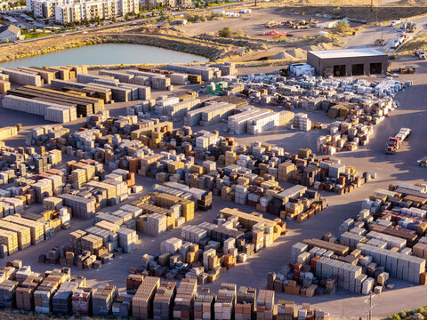 Aerial view of stacks of architectural blocks including bricks, pavers, and cinder blocks arranged in a large industrial storage yard in Bluffdale, Utah, United States.