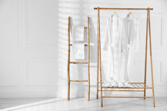 Clean cotton bathrobes and towels in room. Space for text